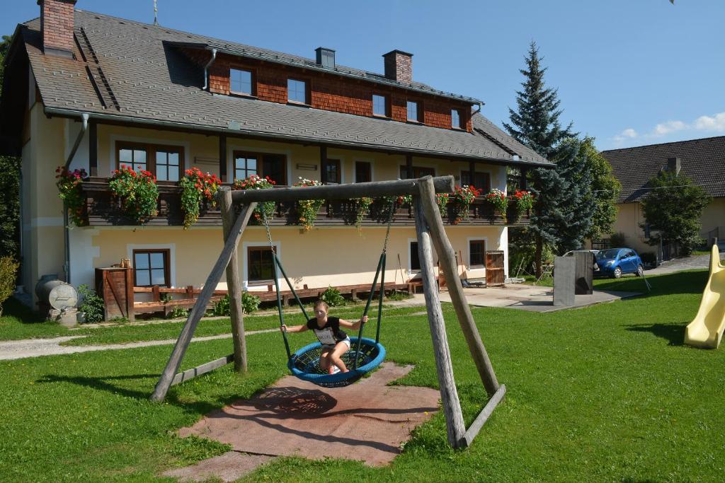 a person sitting on a swing in a yard at Apartment Mauser-Mühltaler in Mauterndorf
