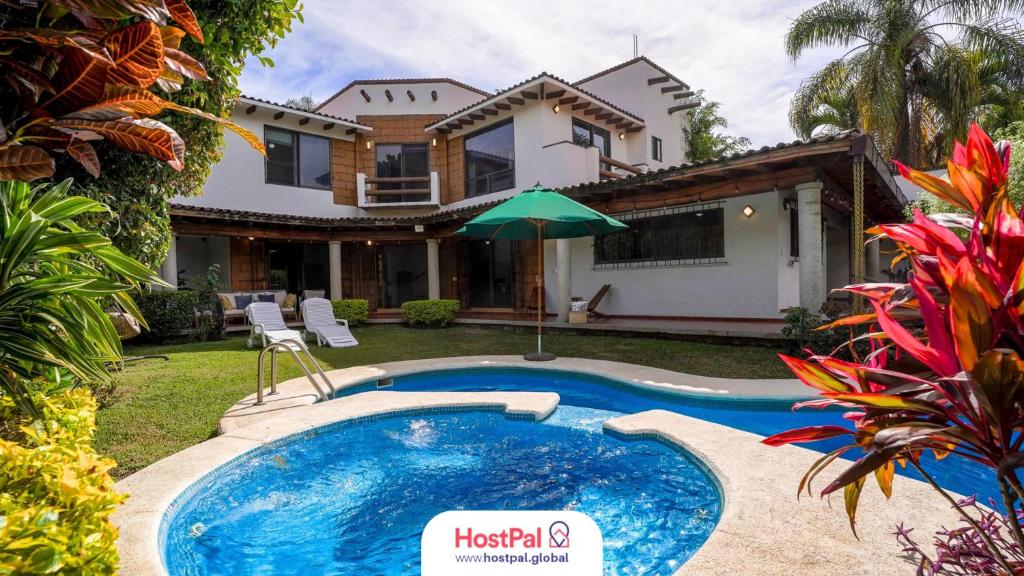 a swimming pool in front of a house at Cozy family house I Pool & Bar l Cuernavaca in Cuernavaca