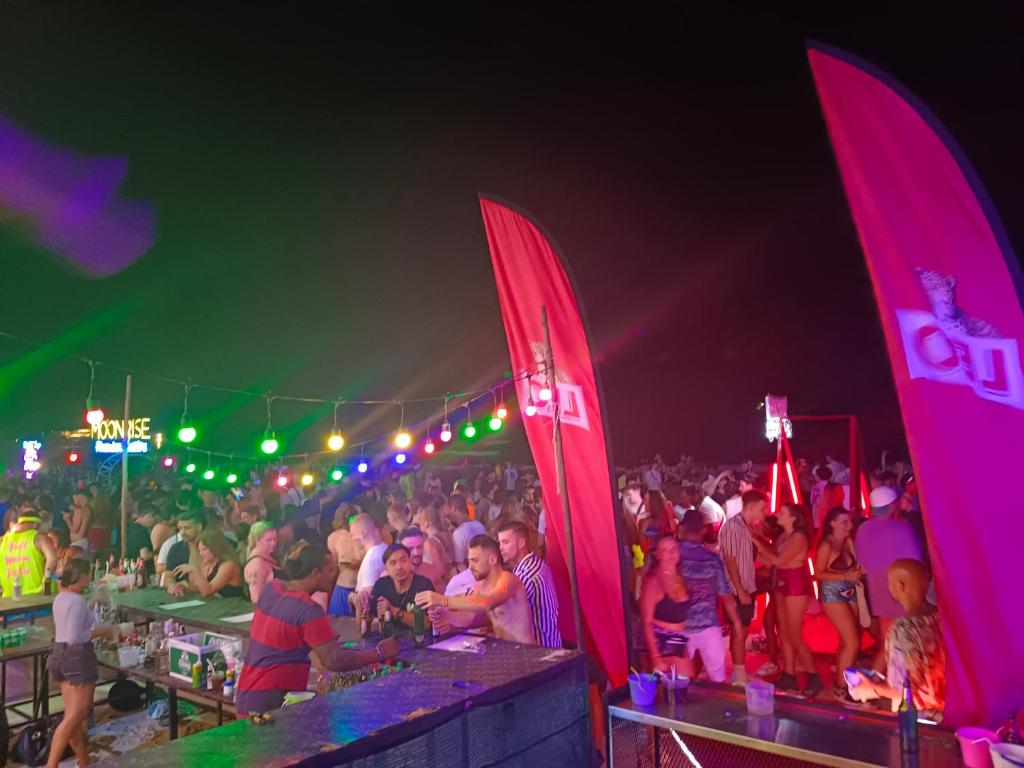 a crowd of people at a party with red sails at Haadrin village Fullmoon in Haad Rin