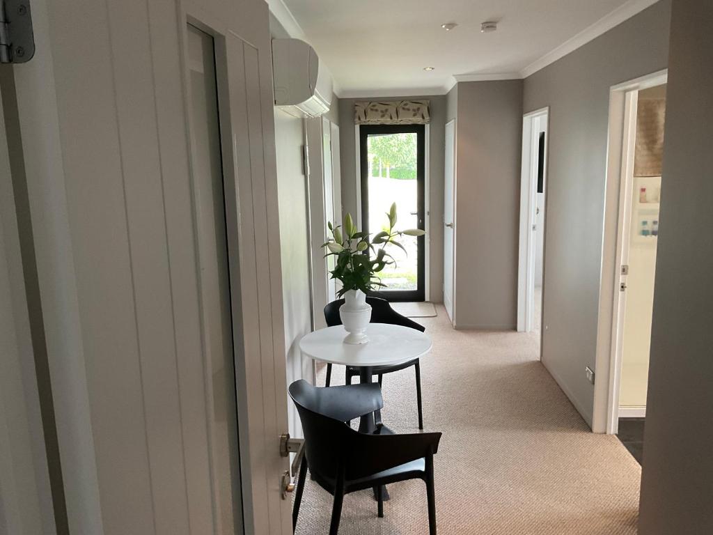 a hallway with a table and chairs in a room at Pegasus Amberley, Entire Studio in Waikuku