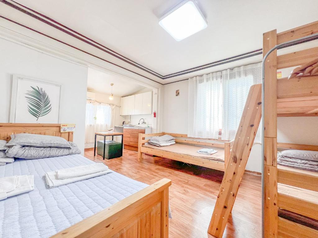 a bedroom with two bunk beds and a ladder at Empathy Guesthouse in Daegu