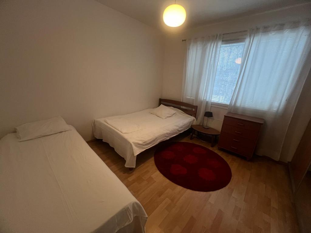 een kleine kamer met 2 bedden en een raam bij Whole Apartment in Vantaa
