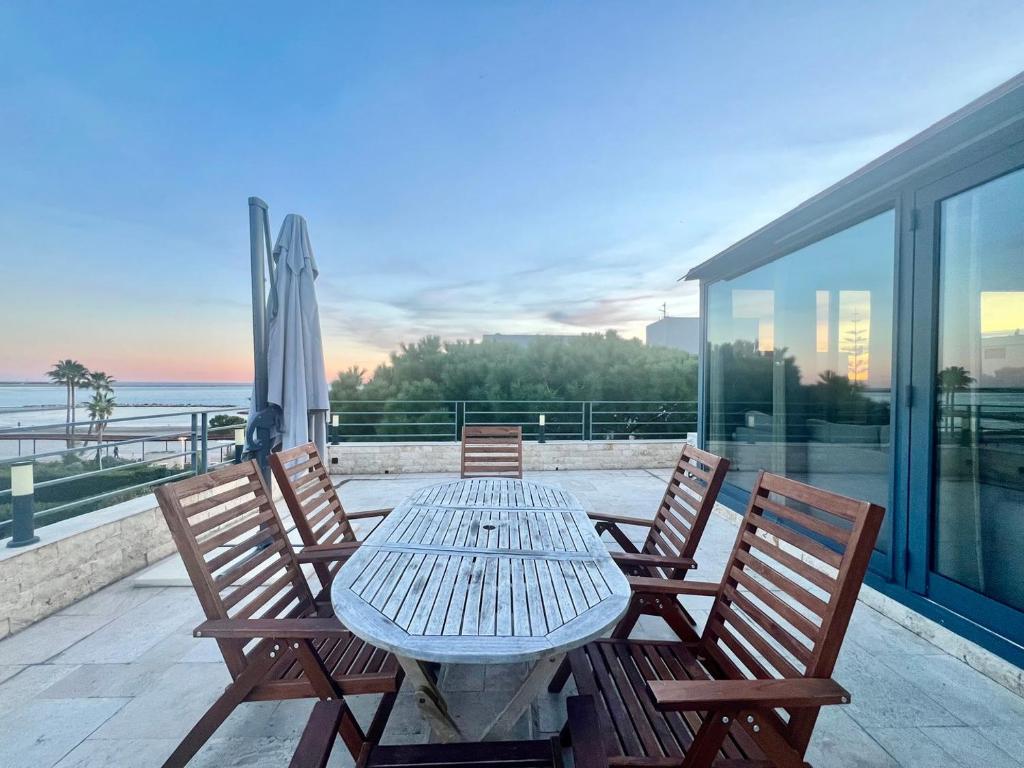 a table and chairs on a balcony with a view of the ocean at Sea and mountain views from your Rooftop ! in Saint-Laurent-du-Var
