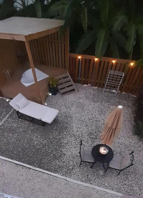 un patio trasero con mesa, sillas y parrilla en Cozyhideaway en Providenciales