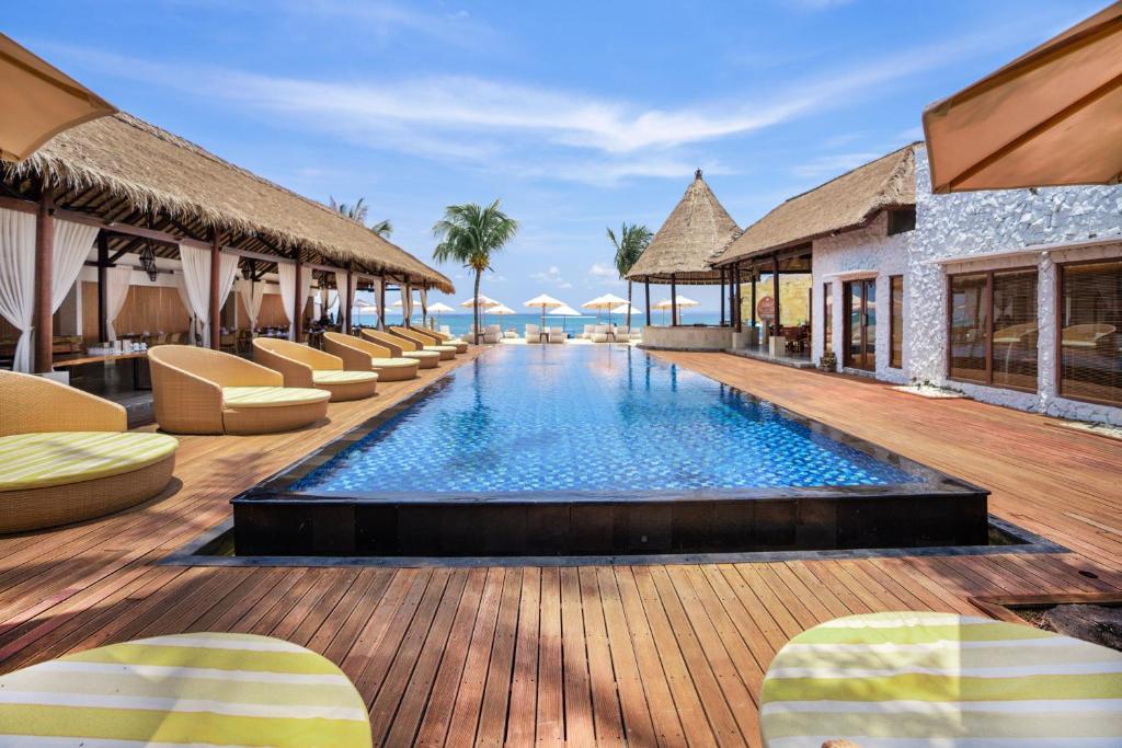 un complexe avec une piscine et des chaises longues dans l'établissement Lembongan Beach Club & Resort, à Nusa Lembongan