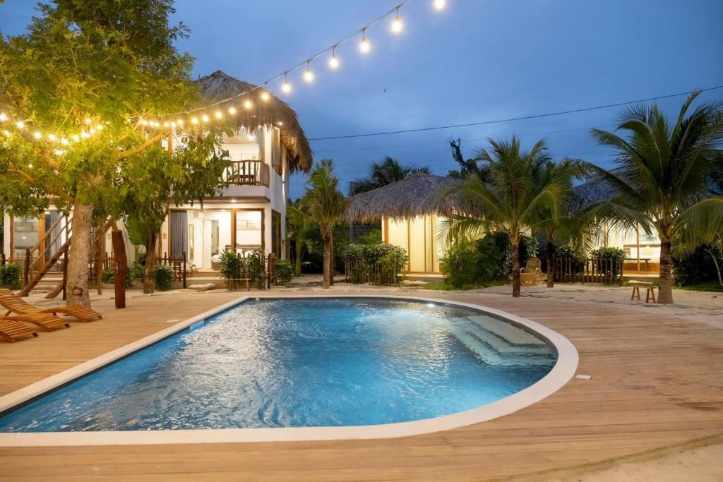 a swimming pool in front of a house with lights at OLIVE Camping in La Gi