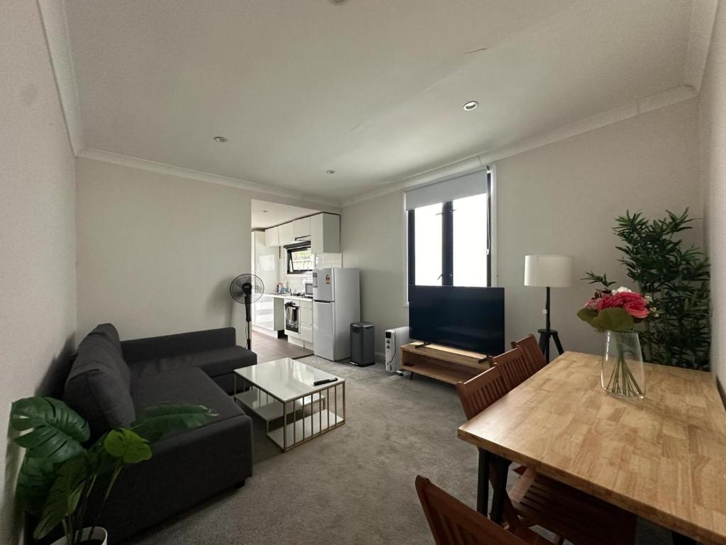 a living room with a black couch and a table at Dynamic 2 Bedroom home close to city buzz Darling St 2 E-Bikes Included in Sydney