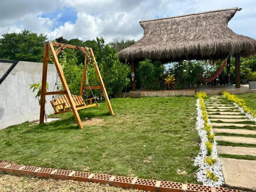 un parco giochi in un giardino con tetto di paglia di CASA FINCA PARA VACACIONAR a Turbaco