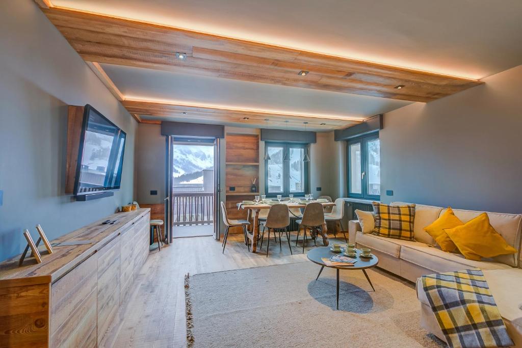 ein Wohnzimmer mit einem Sofa und einem Tisch in der Unterkunft Simona LuxuryApartment Few Steps From Ski - Happy Rentals in Sestriere