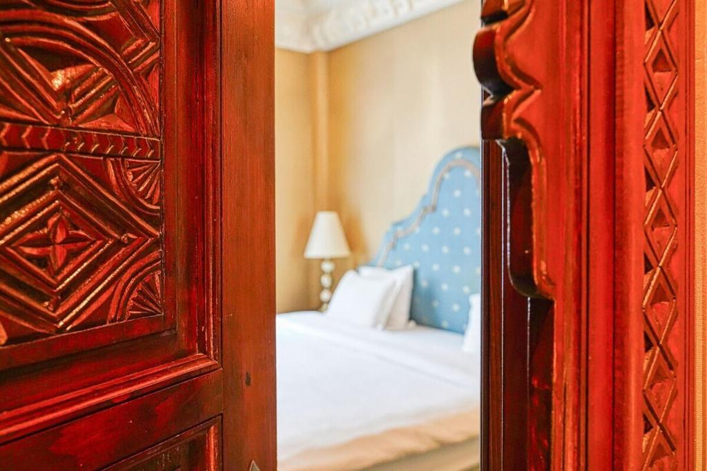 - une chambre avec un lit, un miroir et un sidx sidx dans l'établissement Marrakech Suite Champs Elysees, à Paris