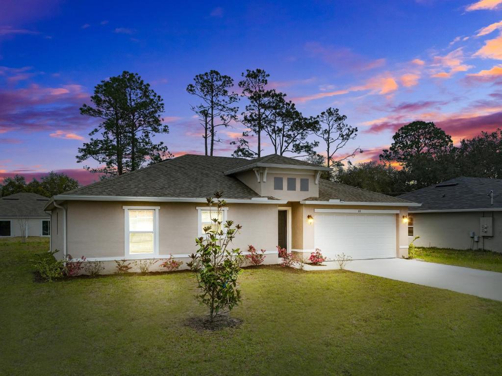 a large white house with a sunset in the background at Sunny Palm Coast: 3BR Harmony in Palm Coast