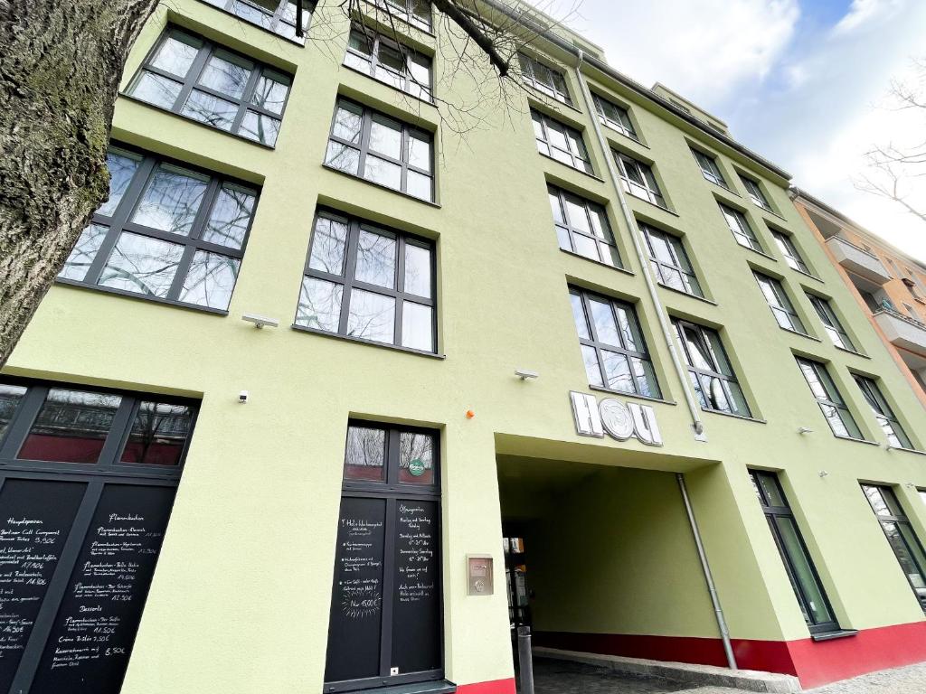 un bâtiment jaune avec beaucoup de fenêtres dans l'établissement HOLI City Apart Hotel Berlin, à Berlin