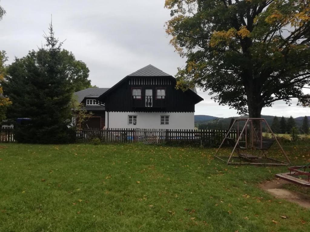 a white house with a black roof at Rejviz apartmany in Zlaté Hory