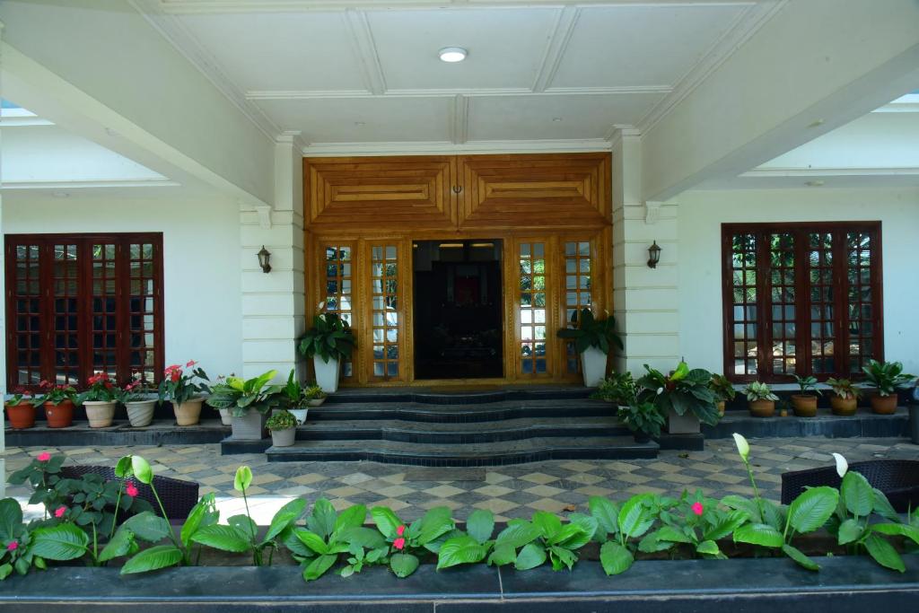 a lobby with potted plants in front of a building at Serenity Cottage Luxury Homestay Virajpet in Virajpet