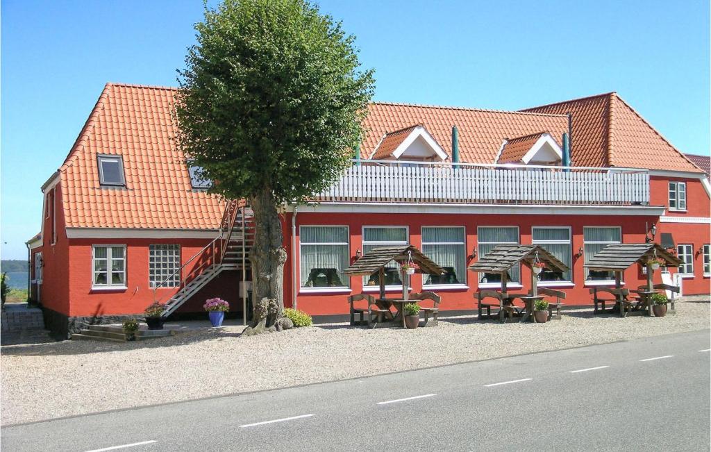 un edificio rojo con mesas y sillas delante de él en Lejl, 2, en Kegnæshøj