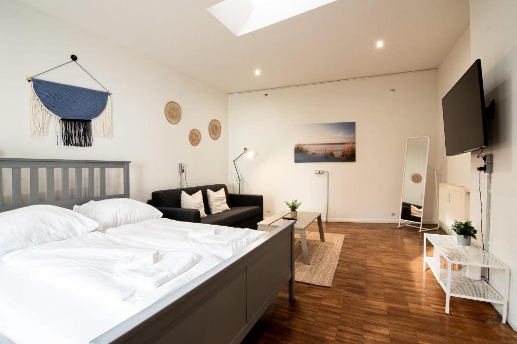 ein Schlafzimmer mit einem großen Bett und ein Wohnzimmer in der Unterkunft Hamburg - 2 Bedrooms for up to 11 guests in Hamburg