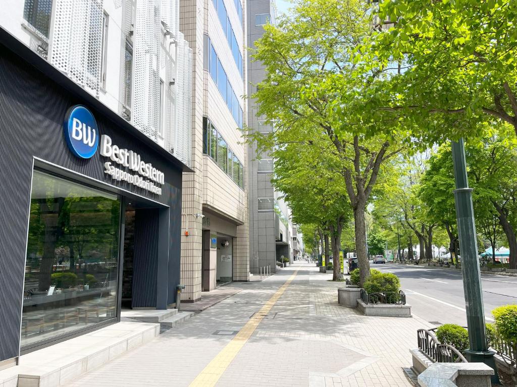 a building with a bmw store on a city street at Best Western Sapporo Odori Koen in Sapporo