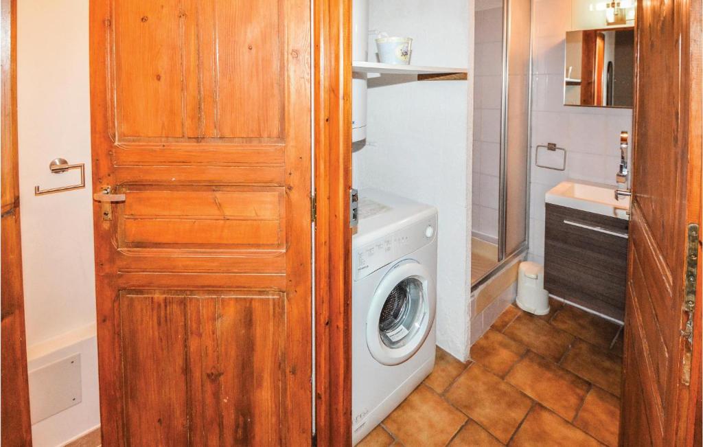 a washing machine in a bathroom with a wooden door at Amazing Home In Barjac With 3 Bedrooms, Wifi And Outdoor Swimming Pool in Barjac