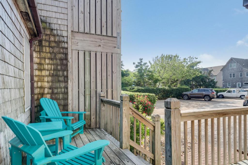 - deux chaises bleues assises sur la terrasse couverte d'une maison dans l'établissement Courtyard Villas on Silver Lake, à Ocracoke