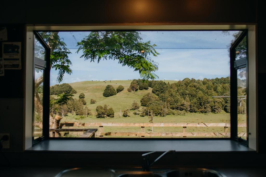 ein Fenster mit Blick auf ein Feld und Bäume in der Unterkunft The Wilderness 