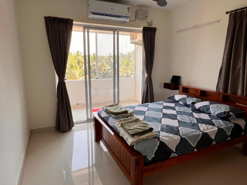 a bedroom with a bed in front of a window at Nirvana Stay, Spacious Fully furnished 2bhk apartment in Mangalore, Full AC in Mangalore