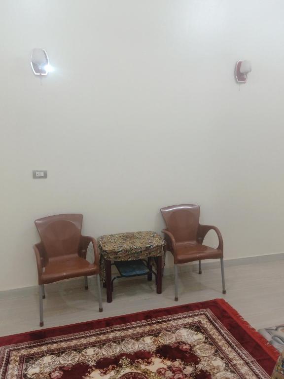 two chairs and a table in a room with a rug at Mooody nobin haws in Abu Simbel
