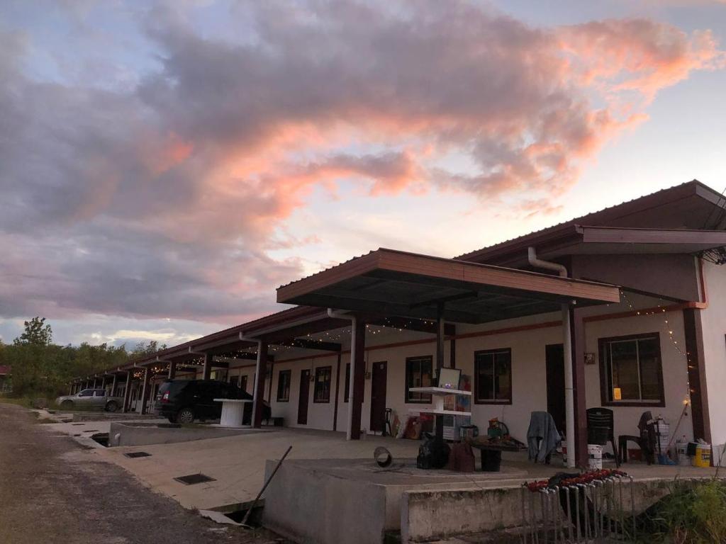 SKE Longhouse Homestay #2 في Sipitang: محطة وقود ذات سماء غائمة في الخلفية
