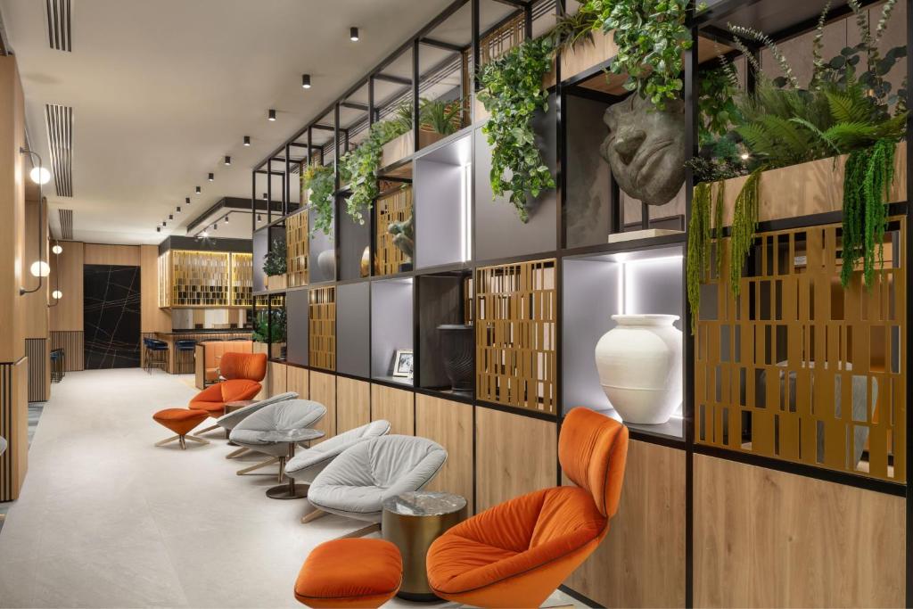 a lobby with a row of chairs and plants at Courtyard by Marriott Cluj - Napoca Downtown in Cluj-Napoca