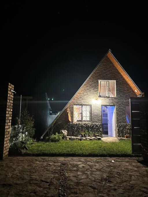 a brick house with a blue door at night at Cabaña María in Siguatepeque