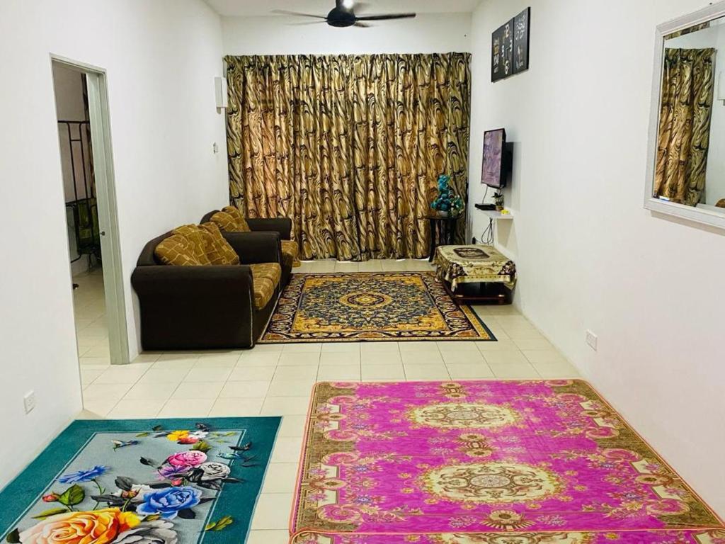 ein Wohnzimmer mit einem Sofa und einem Teppich in der Unterkunft Homestay Teratak Tamu Tawau in Tawau