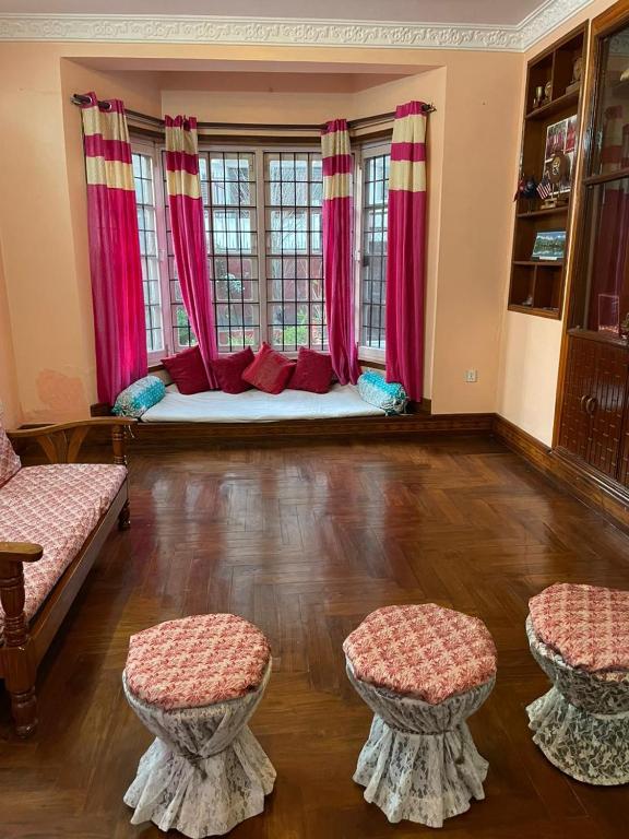 sala de estar con cama con cortinas rosas en Fully furnished 1bhk flat near dhumbarahi area en Katmandú