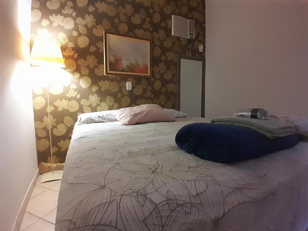 Dormitorio con cama con pared de flores en Apartamento Próximo ao Ribeirao Shopping, en Ribeirão Preto