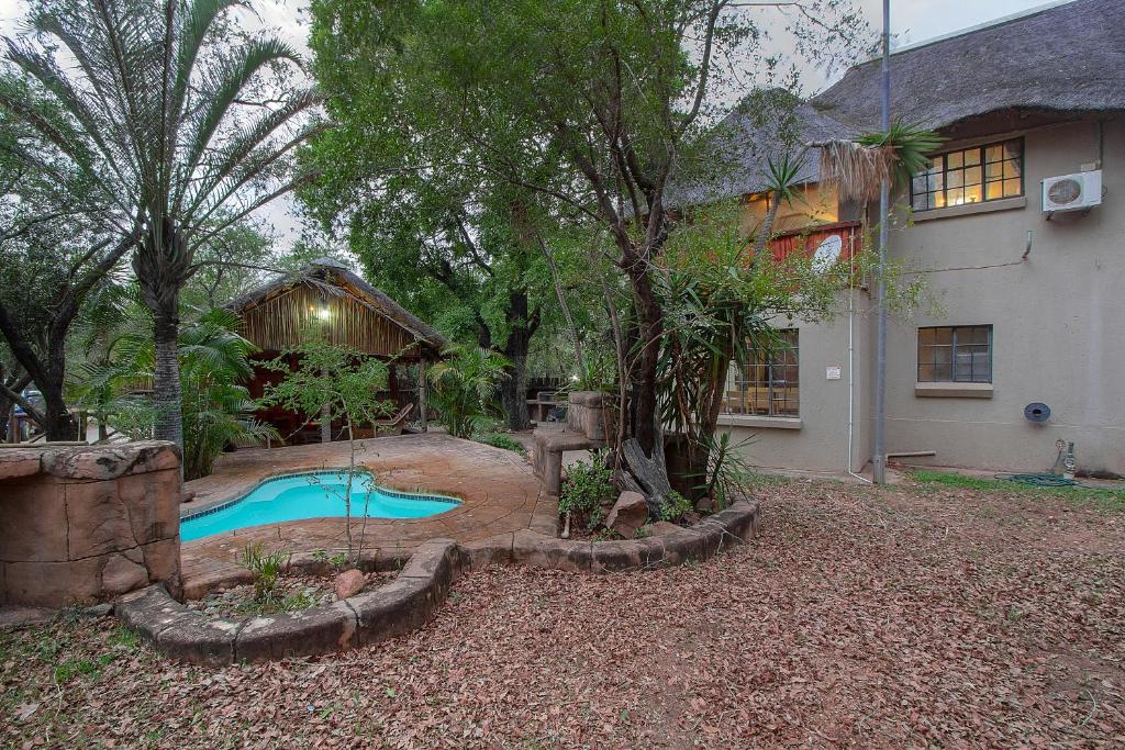 a backyard with a swimming pool and a house at Marloth Kruger Little Manor in Marloth Park