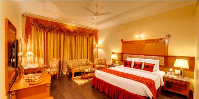 a hotel room with a large bed and a couch at HOTEL BABYLON INTERNATIONAL in Raipur