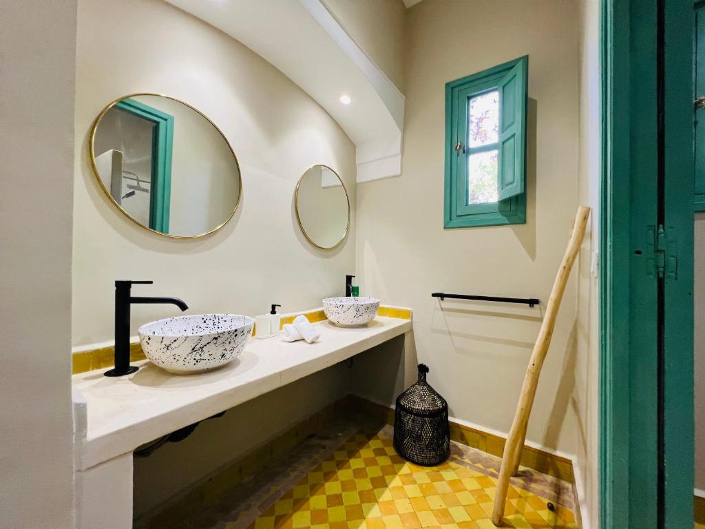 een badkamer met een wastafel en 2 spiegels bij Charming Villa with Pool, Garden and Pingpong in Marrakesh