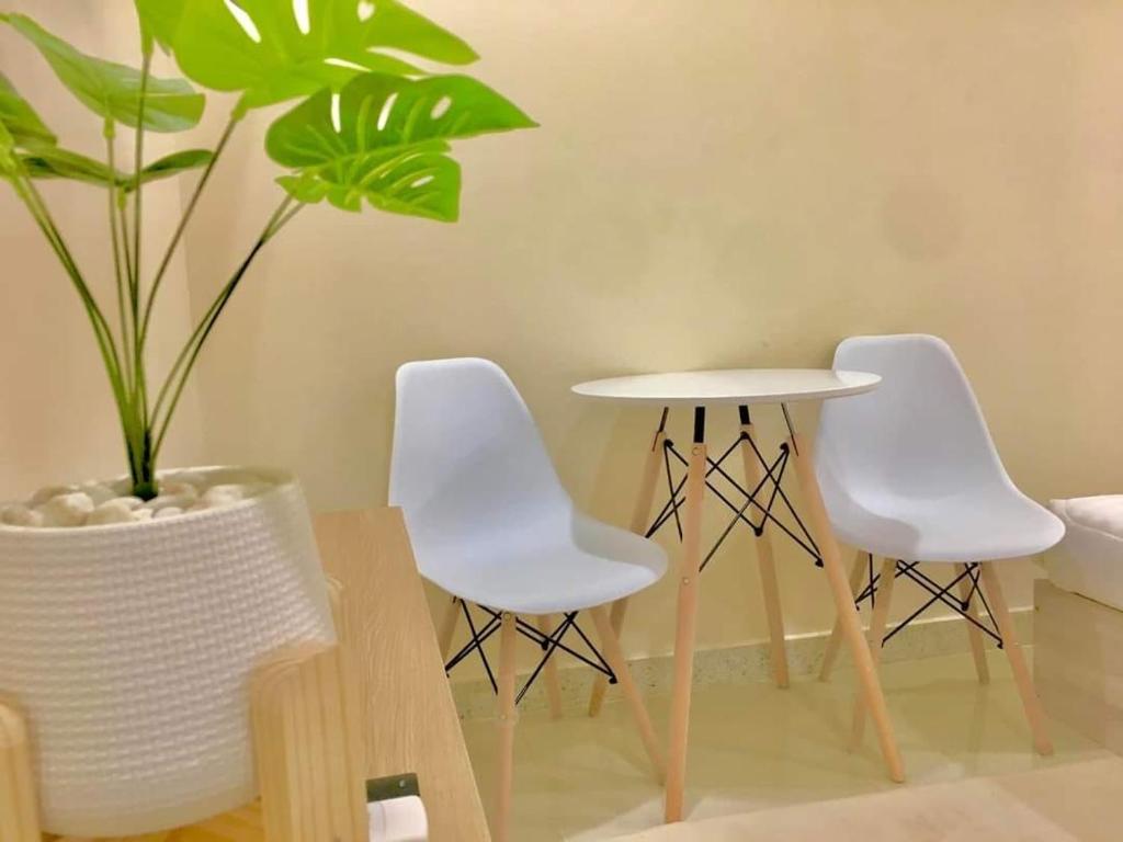 drie witte stoelen en een tafel en een plant bij ทีเคอพาร์ทเม้นท์ สงขลา in Ban Nam Krachai