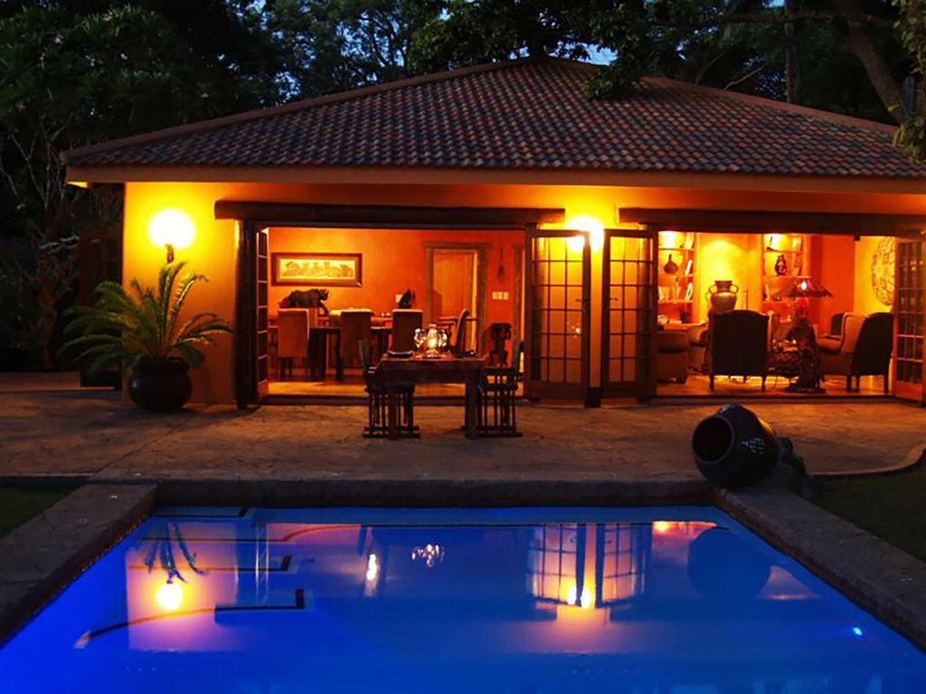 a house with a swimming pool at night with lights at Kwalucia Private Safari Retreat in St Lucia