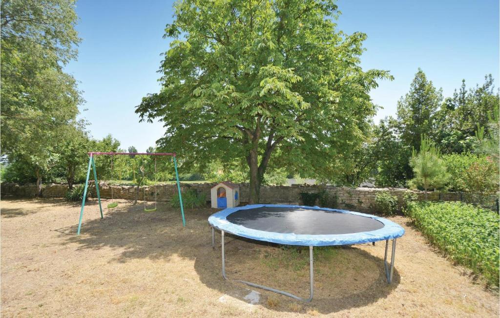 an empty trampoline in a yard with a tree at Amazing Home In Barjac With 3 Bedrooms, Wifi And Outdoor Swimming Pool in Barjac