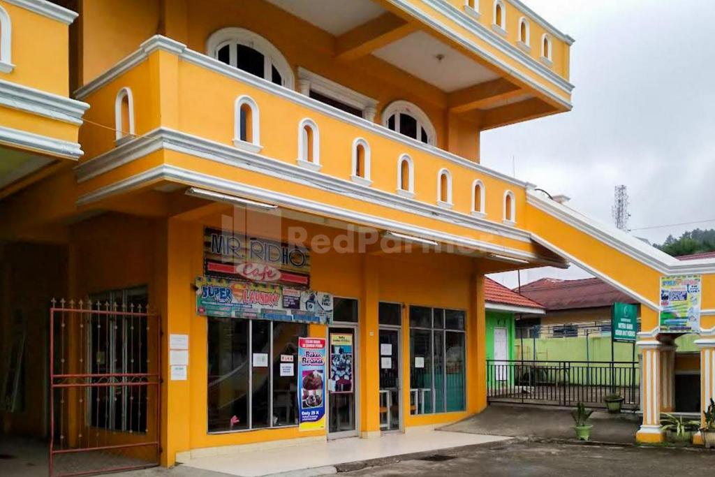 een groot geel gebouw met een winkel bij Hotel Jaya Wisata RedPartner in Sungaipenuh
