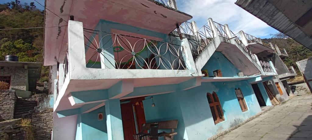 un edificio azul y blanco con balcón en Bhumika Home Stay, en Kapkot