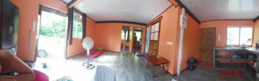 een woonkamer met oranje muren en een groot raam bij Marupo Room in Fare