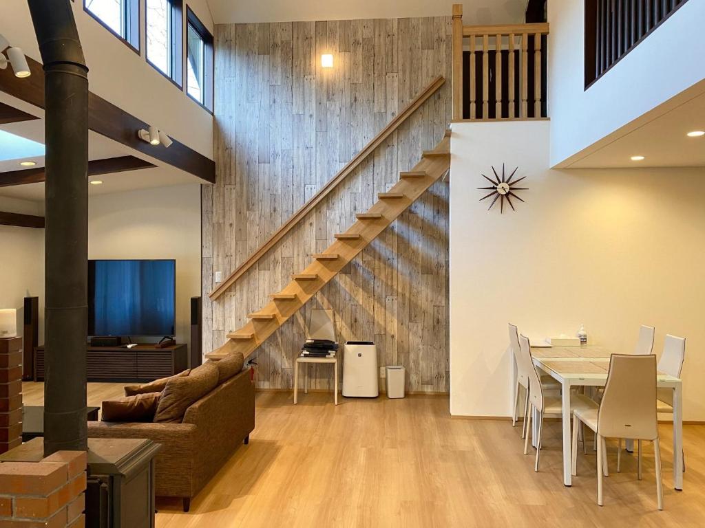 sala de estar con escalera, mesa y sillas en Rental Villa Karuizawa Honors Hill - Vacation STAY 02160v en Oiwake