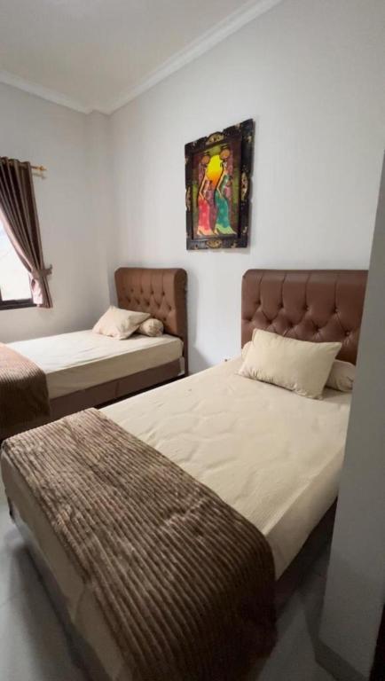 Postel nebo postele na pokoji v ubytování Hens Guesthouse Syariah