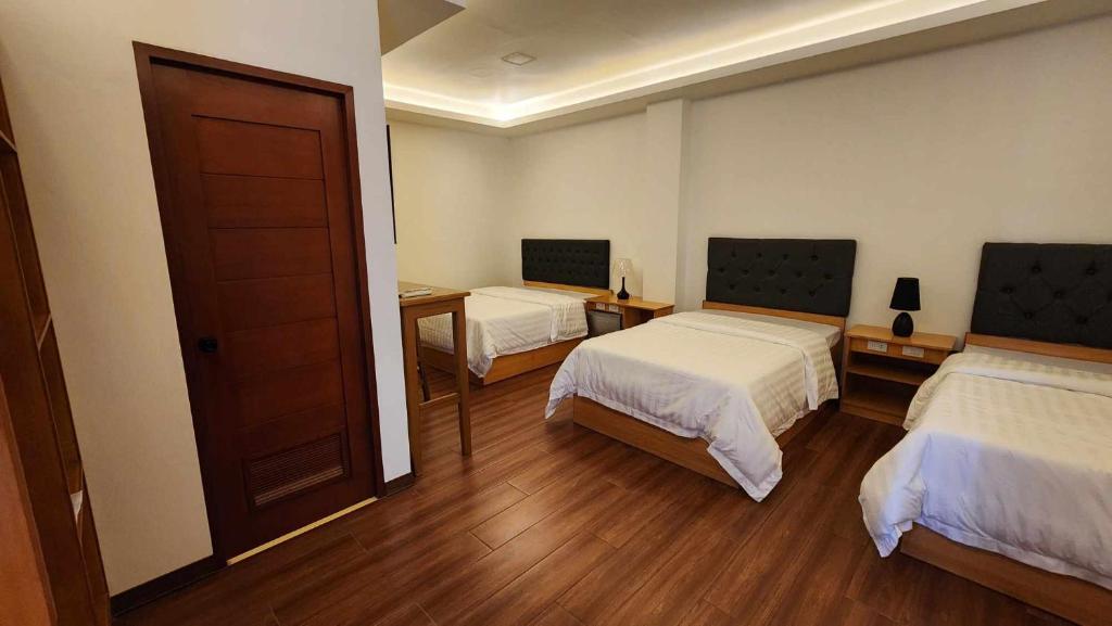 ein Hotelzimmer mit 2 Betten und einer Tür in der Unterkunft Fountainblue 