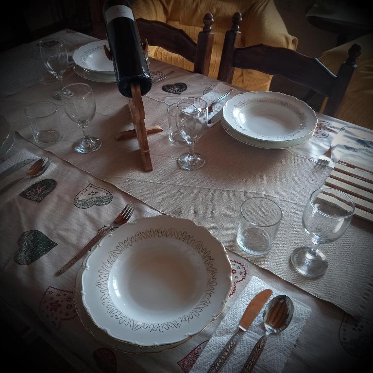 a table with plates and wine glasses on a table at Villa Malini in Grožnjan