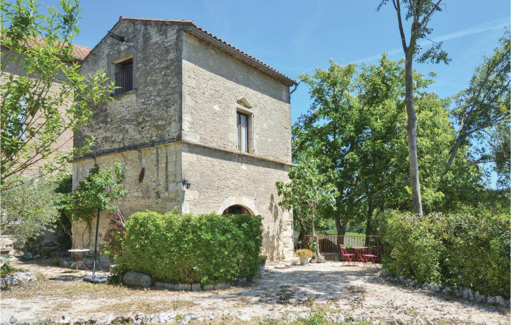 an old stone house with bushes in front of it at Amazing Home In Barjac With 3 Bedrooms, Wifi And Outdoor Swimming Pool in Barjac