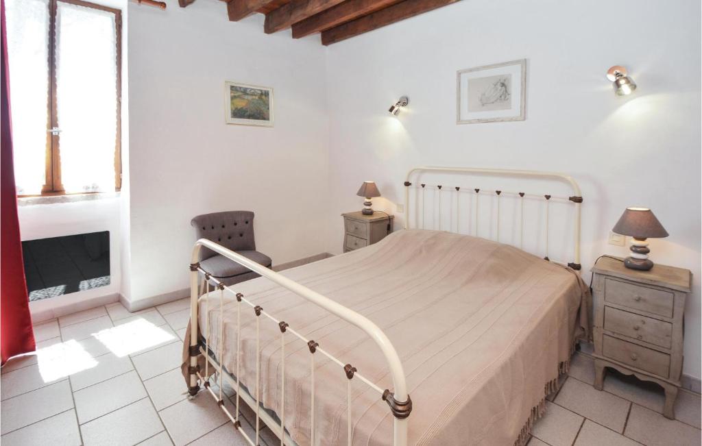 a white bedroom with a bed and a tv at Amazing Home In Barjac With 3 Bedrooms, Wifi And Outdoor Swimming Pool in Barjac