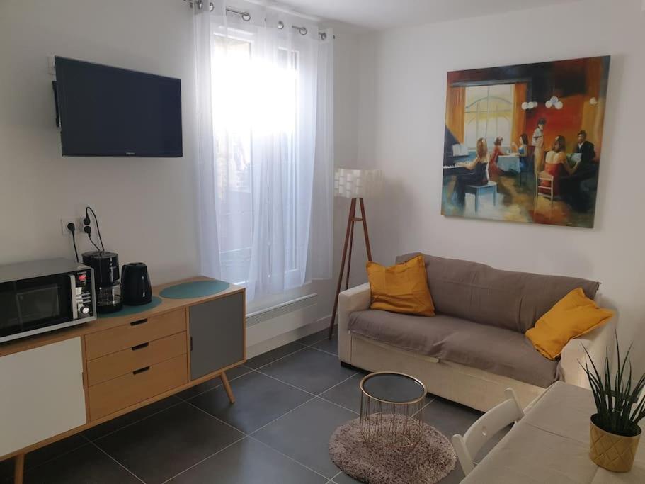 - un salon avec un canapé et une télévision dans l'établissement Bel appartement avec patio, à Villejuif