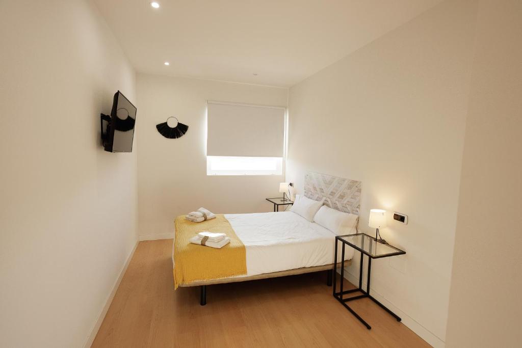 1 dormitorio pequeño con 1 cama y 2 mesas en Habitación Villanubla, en Villanubla