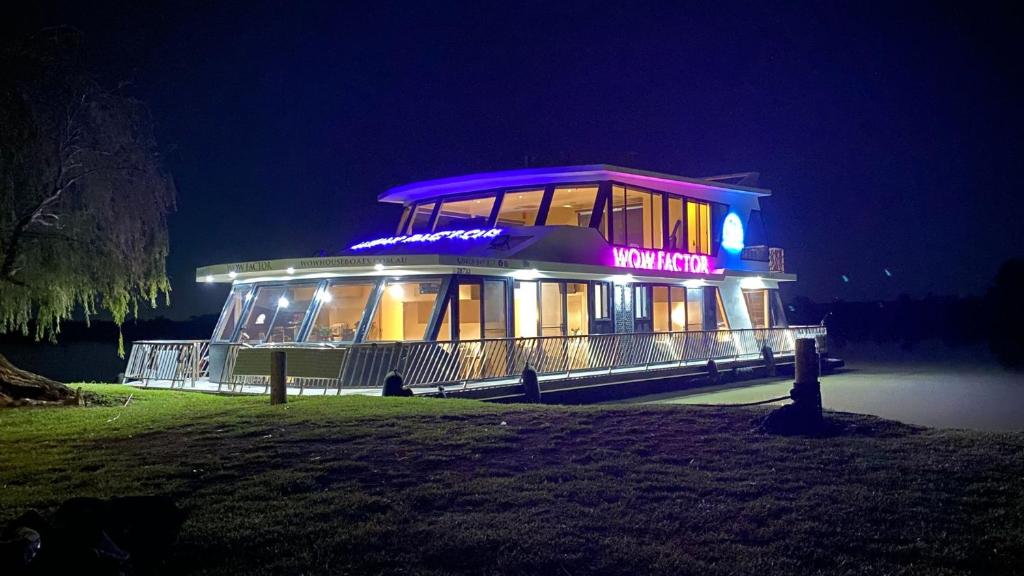 - un bâtiment éclairé avec un panneau la nuit dans l'établissement Wow Houseboats Pty Ltd, à White Sands